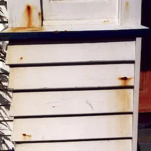 Rust stains bleeding down the face of the boards from every fixing.